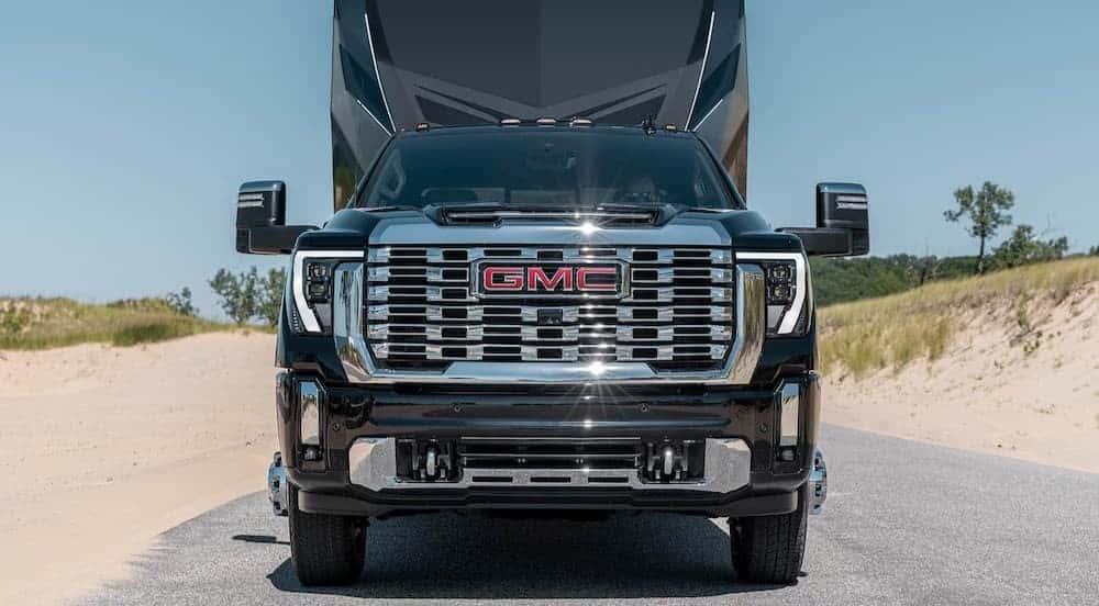 A black 2026 GMC Sierra 3500 HD towing a trailer.