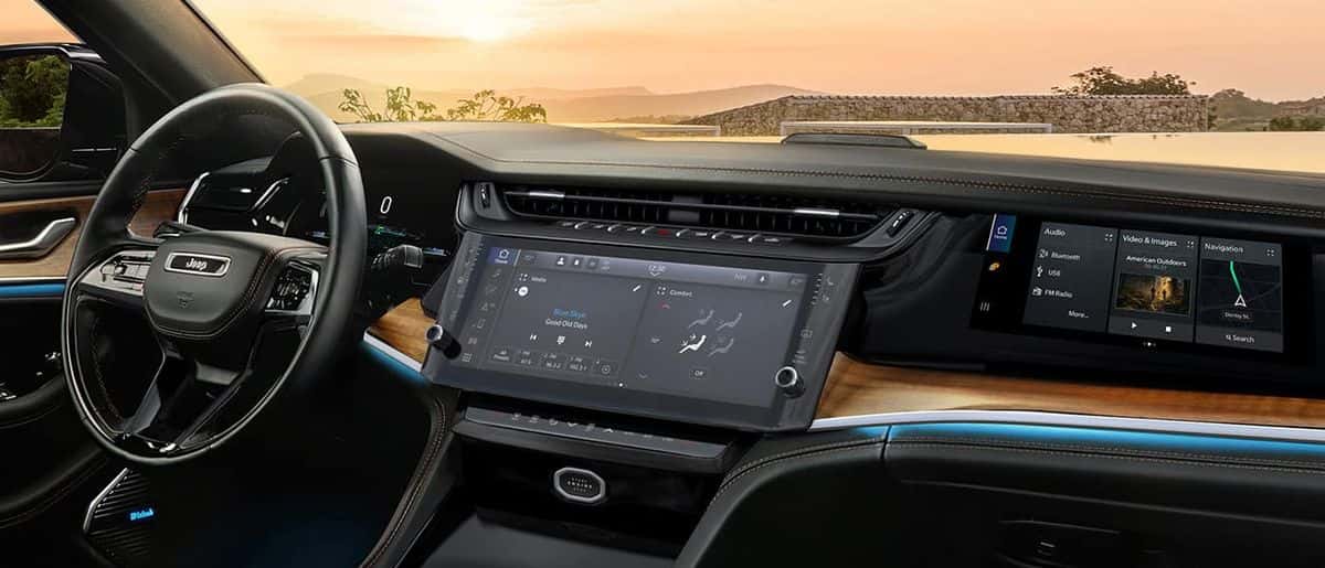 Dashboard of a 2026 Jeep Grand Cherokee showing the 12.3-inch Uconnect 5 touchscreen with media and climate controls