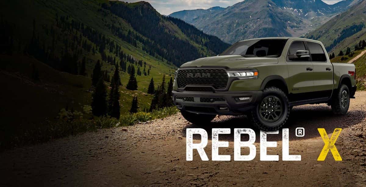 Green 2026 Ram 1500 Rebel X on a mountain trail with the Rebel X logo