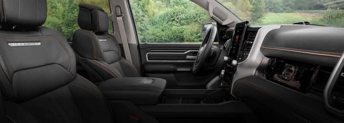 Black leather front seats and tall touchscreen inside a 2026 Ram 1500 Tungsten 4x4 Crew Cab