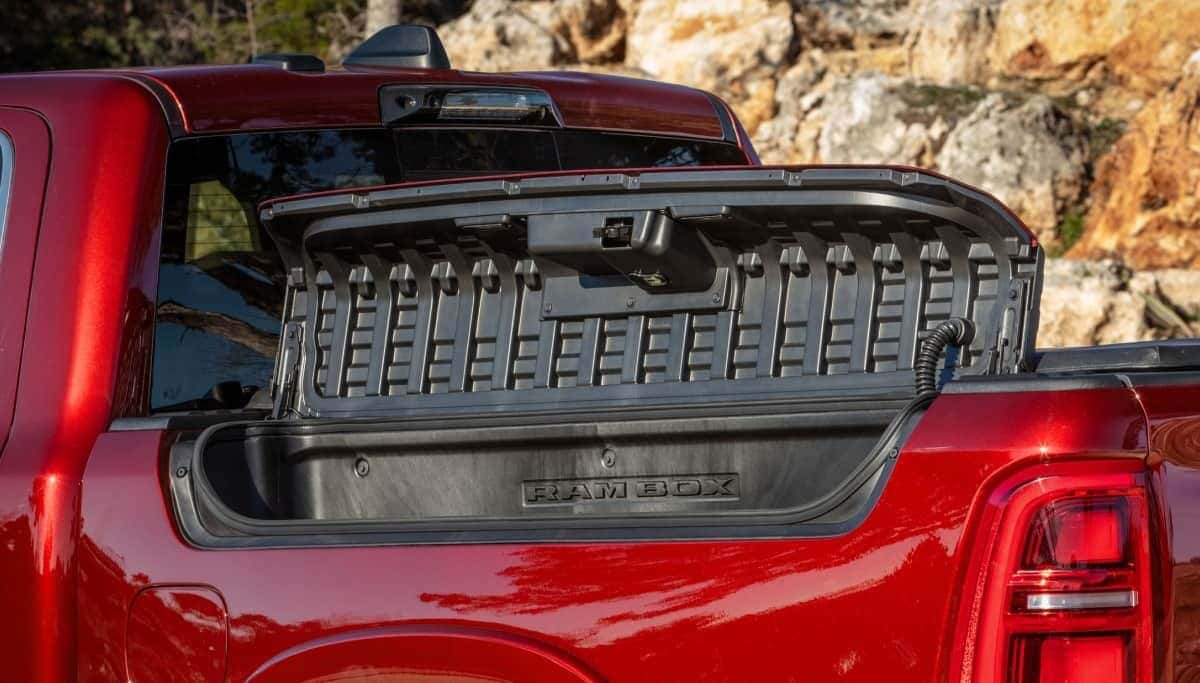 Open RamBox cargo management storage in the bed side of a red 2026 Ram 1500 Tungsten 4x4 Crew Cab