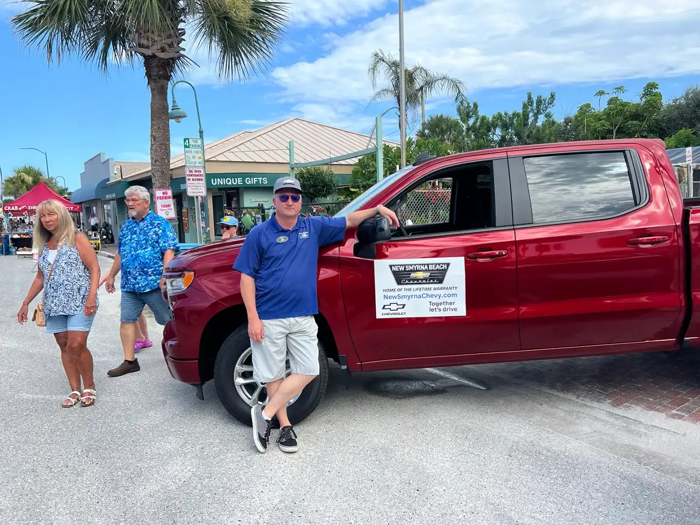 New Smyrna Beach Chevrolet team member at Flagler Avenue event with red Silverado