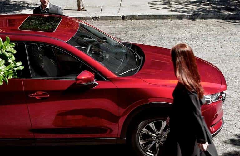 woman walking near a red 2019 Mazda CX-5