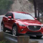 red 2021 Mazda CX-3 driving around corner