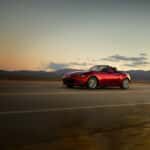 red mazda miata driving on empty highway