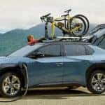 women next to charging subaru