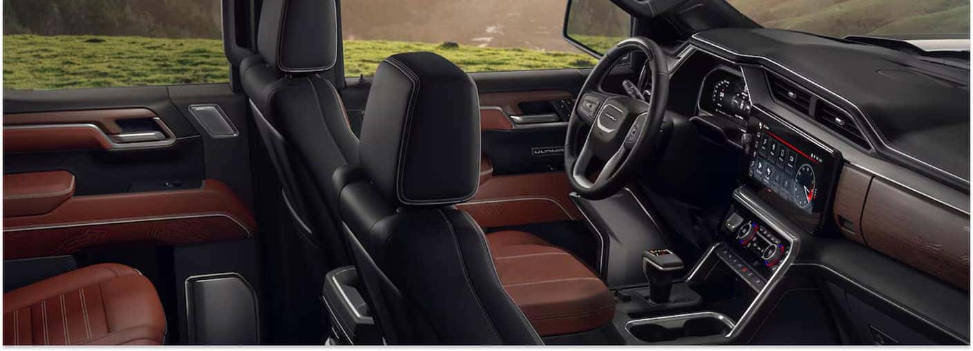 Front cabin interior of a 2026 GMC Sierra 1500 Denali Ultimate showing brown leather seats and center console display.