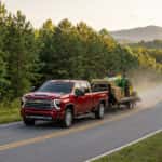 2026 Chevrolet Silverado 2500 HD towing a flatbed trailer on a rural road in Richmond County, NC