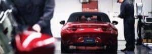 Mazda-Service-Technician-looking-over-a-vehicle
