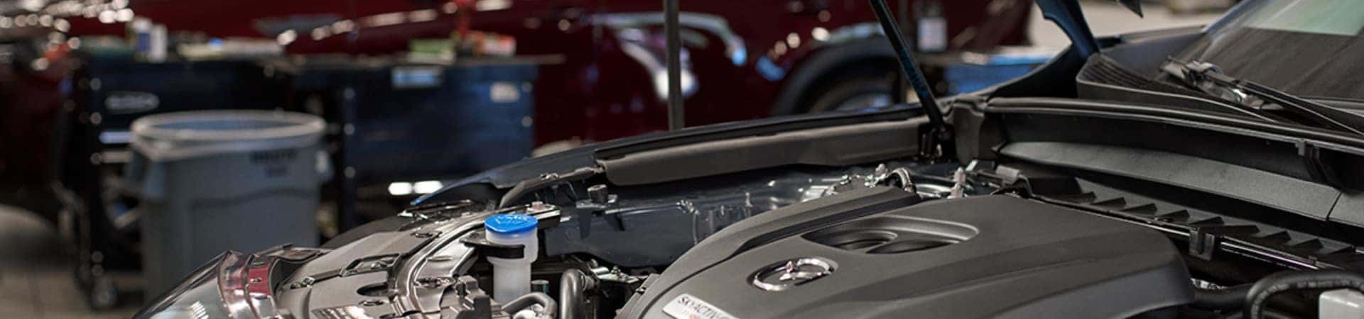 Mazda-Service-Technician-looking-over-a-vehicle