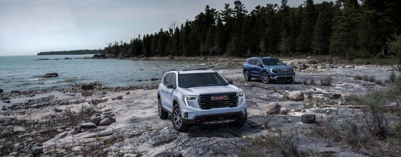 Two 2024 GMC Acadia AT4 parked by the water