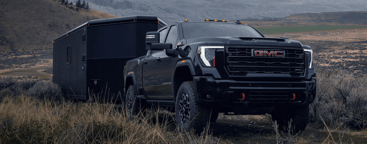 Black 2026 GMC Sierra 2500 HD towing a trailer