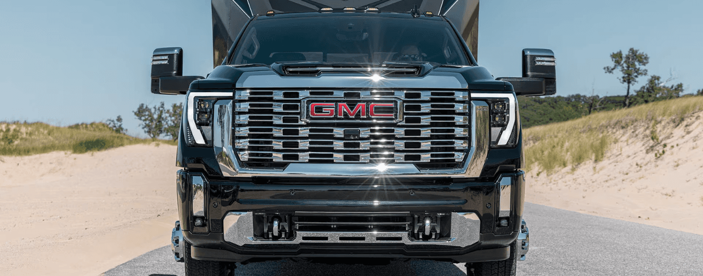 Close-up of grille and badge of a black 2026 GMC Sierra 2500 HD