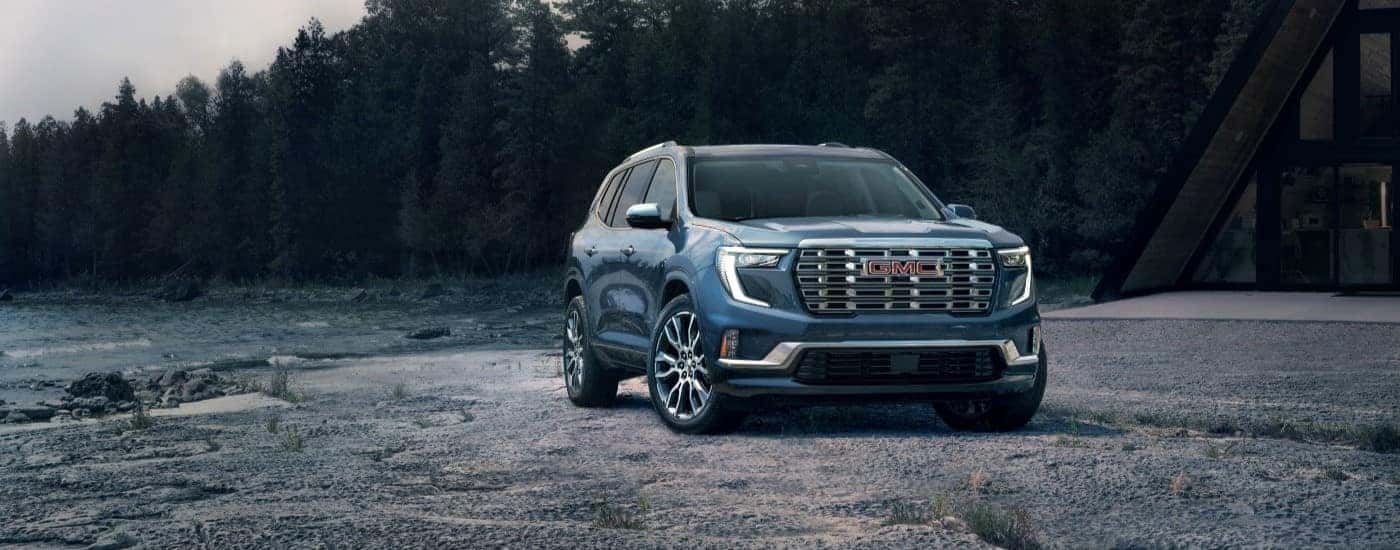 Blue 2024 GMC Acadia Denali parked off-road