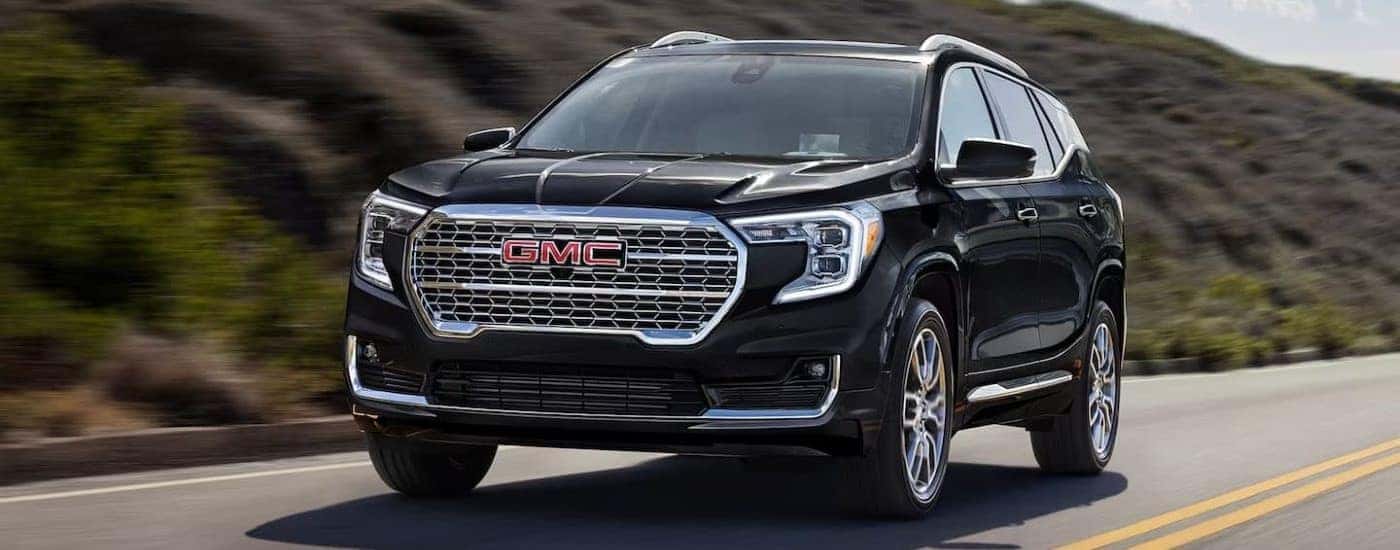 A black 2024 GMC Terrain Denali shown driving.