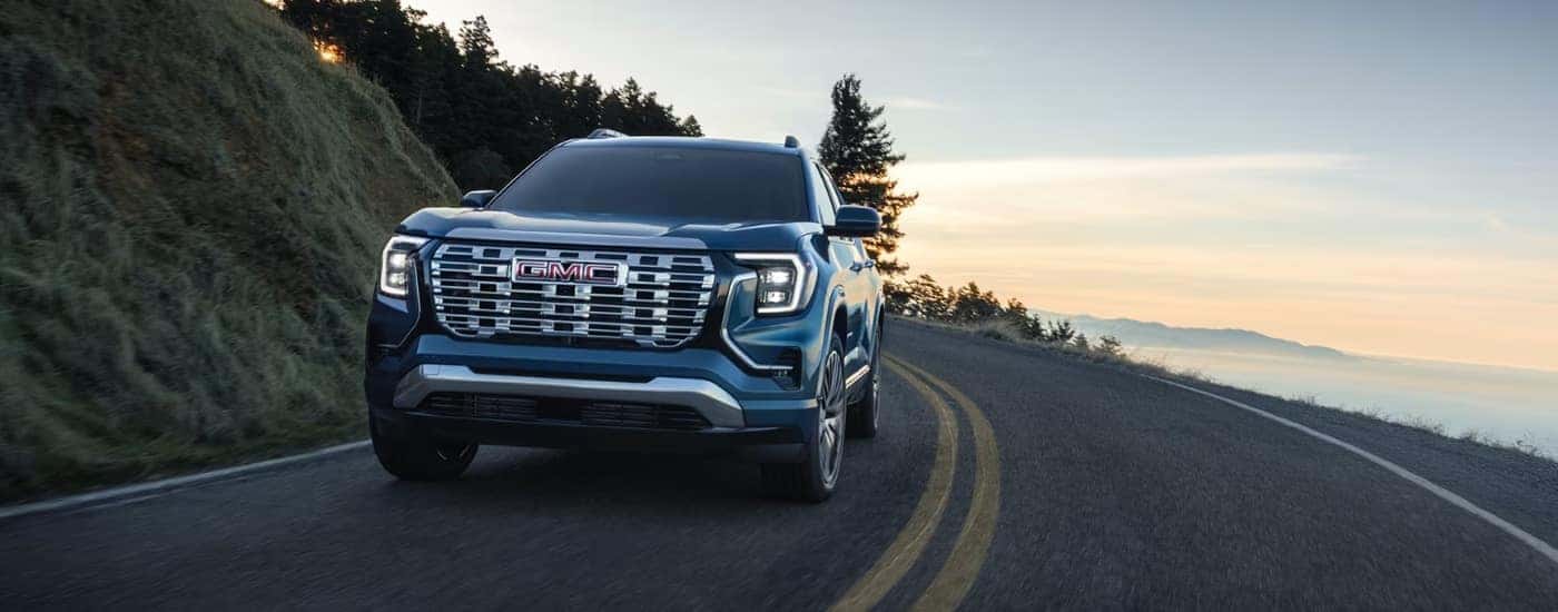 A blue 2026 GMC Terrain turning a corner.