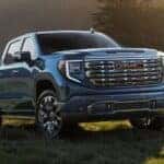 A blue 2026 GMC Sierra 1500 Denali shown parked on a grass field.