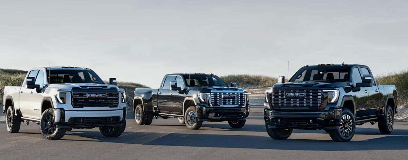 A lineup of three 2026 GMC Sierra HD trucks parked near each other.