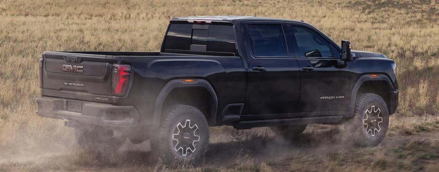 Black 2026 GMC Sierra 2500 HD driving through dirt