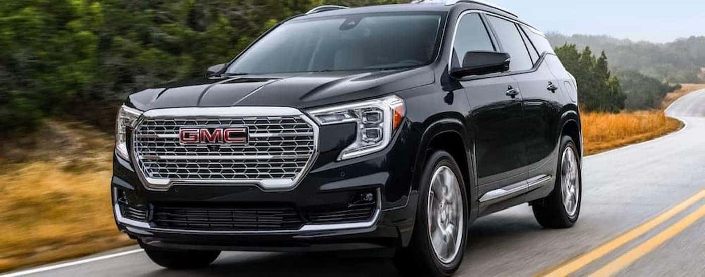 A black 2023 GMC Terrain Denali driving on a highway.