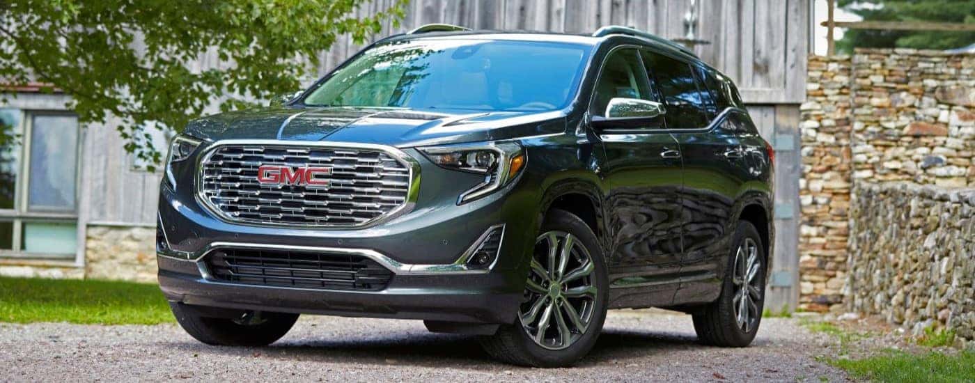 Black 2020 GMC Terrain Denali parked in front of a barn.