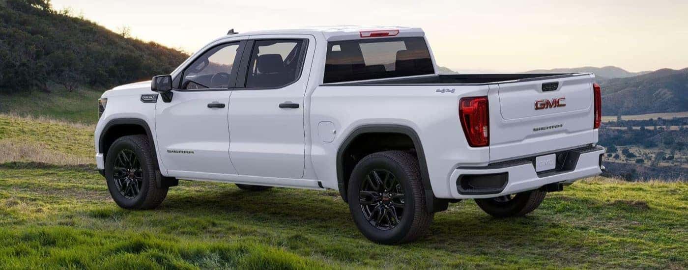 White 2024 GMC Sierra 1500 parked in a grassy field.