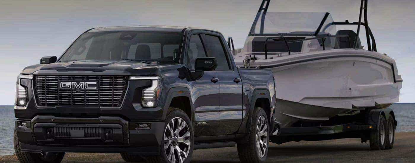 Black 2027 GMC Sierra 1500 Denali towing a boat.