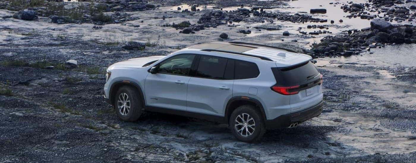 A white 2024 GMC Acadia AT4 parked offroad.