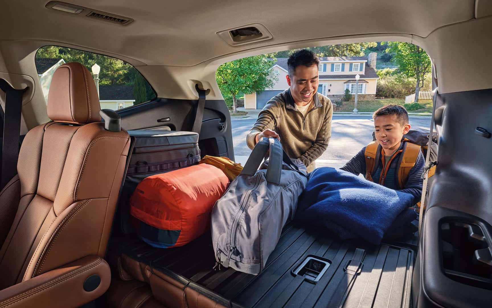 View from within of a dad and son loading cargo into the rear of the Ascent Tourring with Brown Nappa Leather