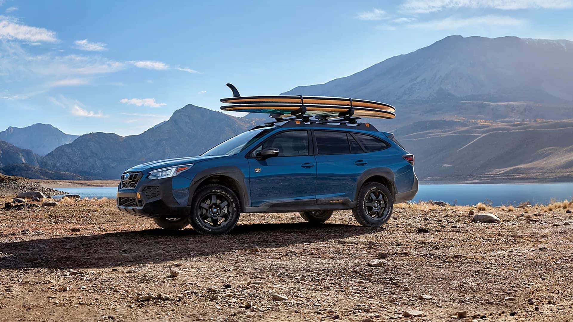Side View of Subaru Outback Wilderness with Surboards on Top