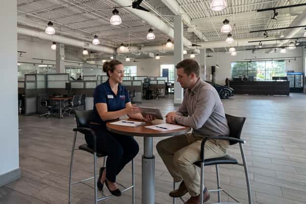 Customers seated at a table on the Serra Toyota Lincolnwood showroom floor