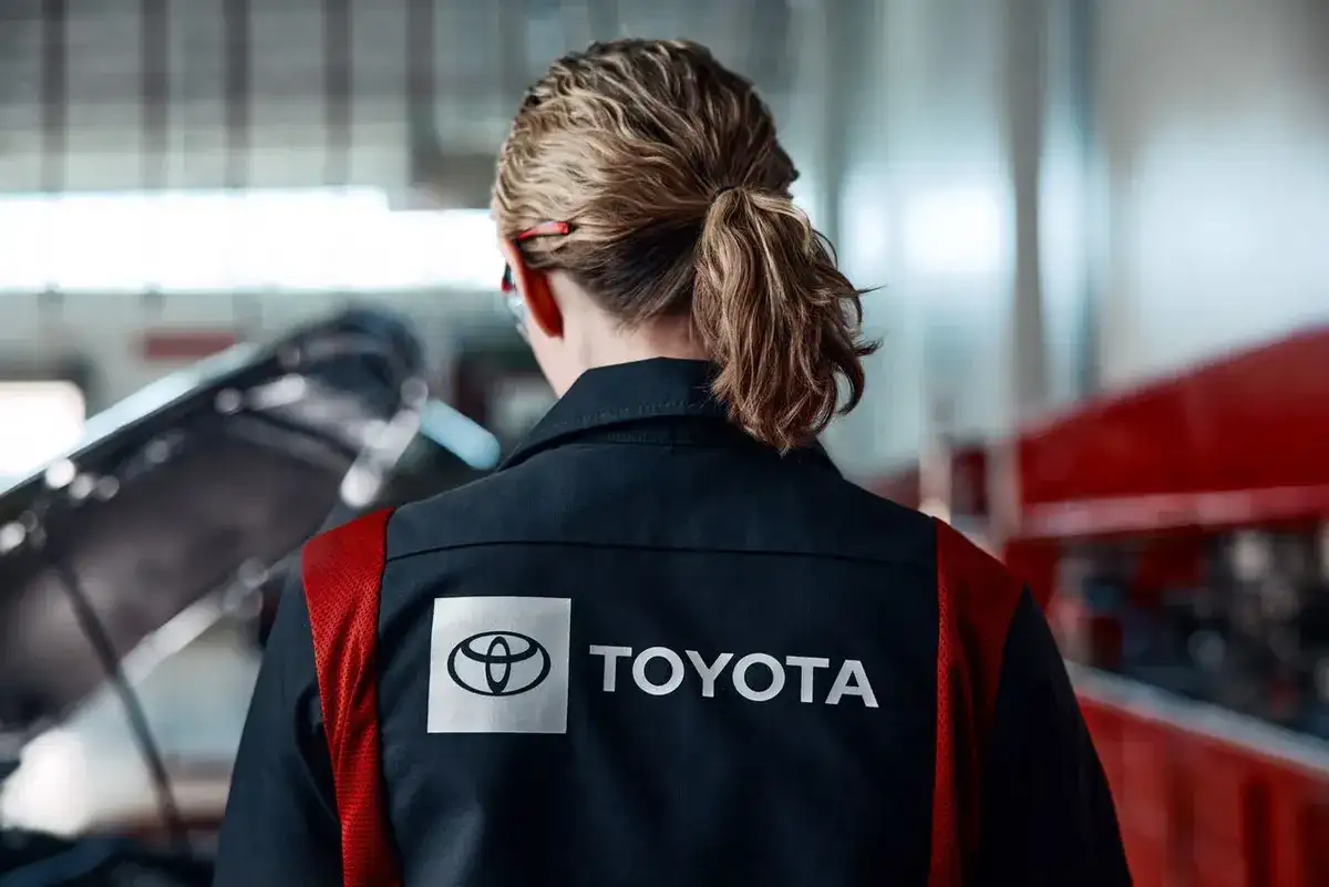Technician wearing a Toyota uniform jacket working in a service bay
