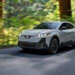 subaru driving on road in forest