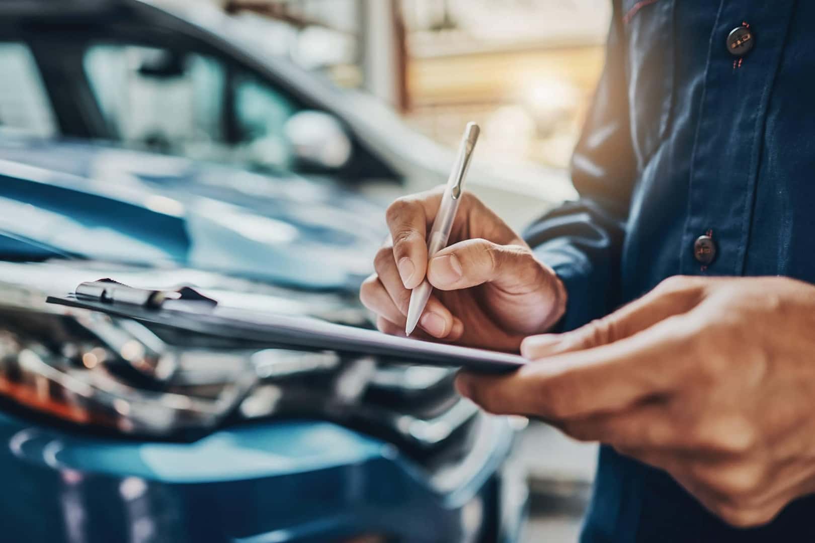 filling out paperwork on a clipboard by vehicle