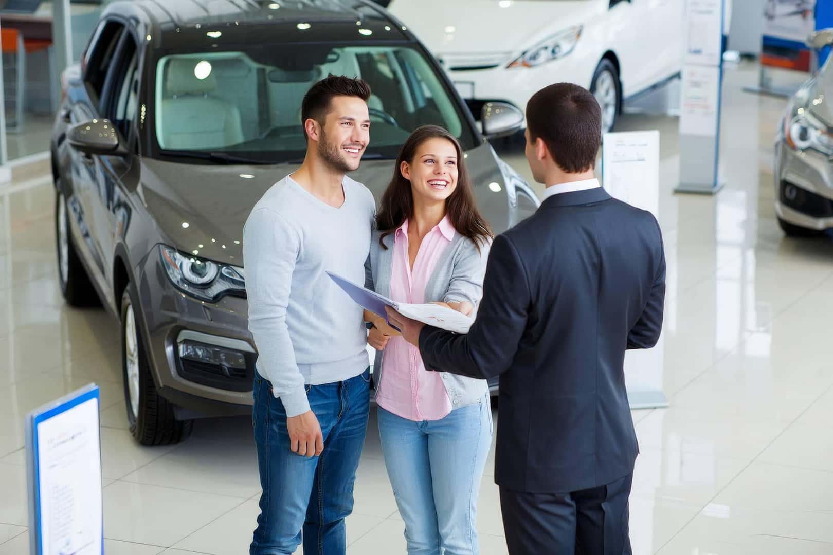 couple talking to a salesman at dealership