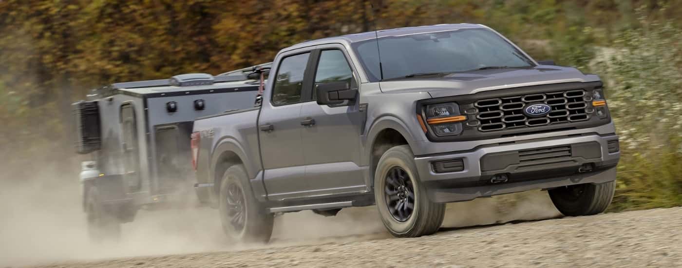 A silver 2026 Ford F-150 towing a trailer