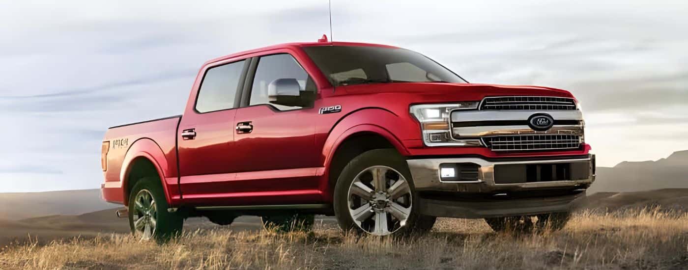 A red 2020 Ford F-150 is shown parked in a dry grassy field.
