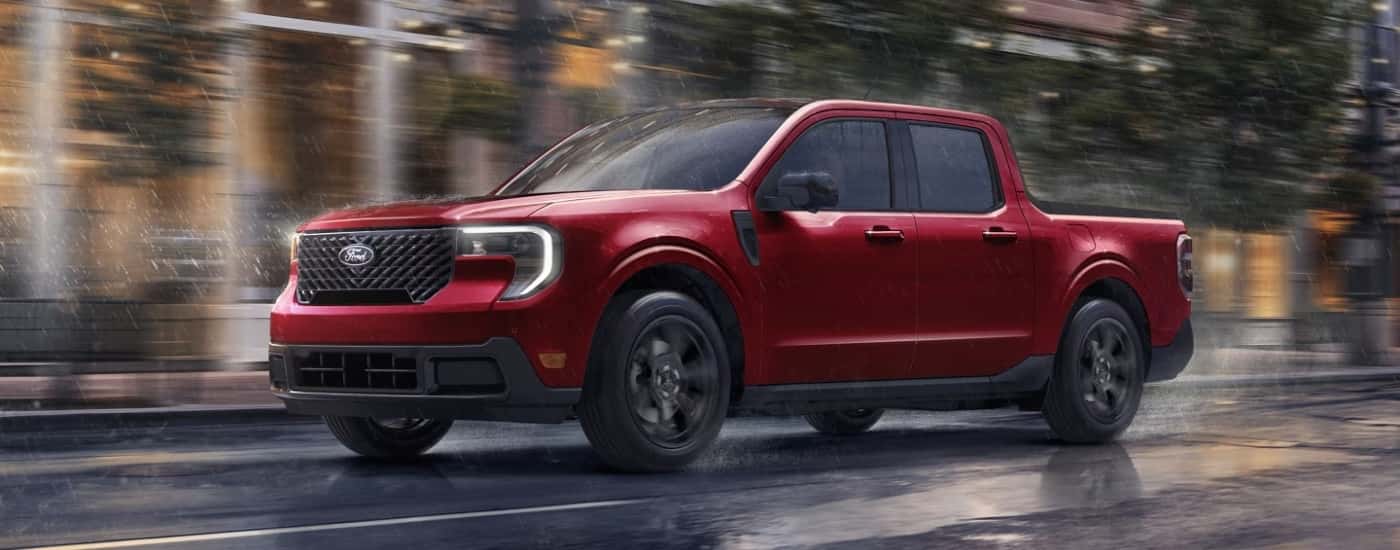 A red 2025 Ford Maverick driving on a rainy street.