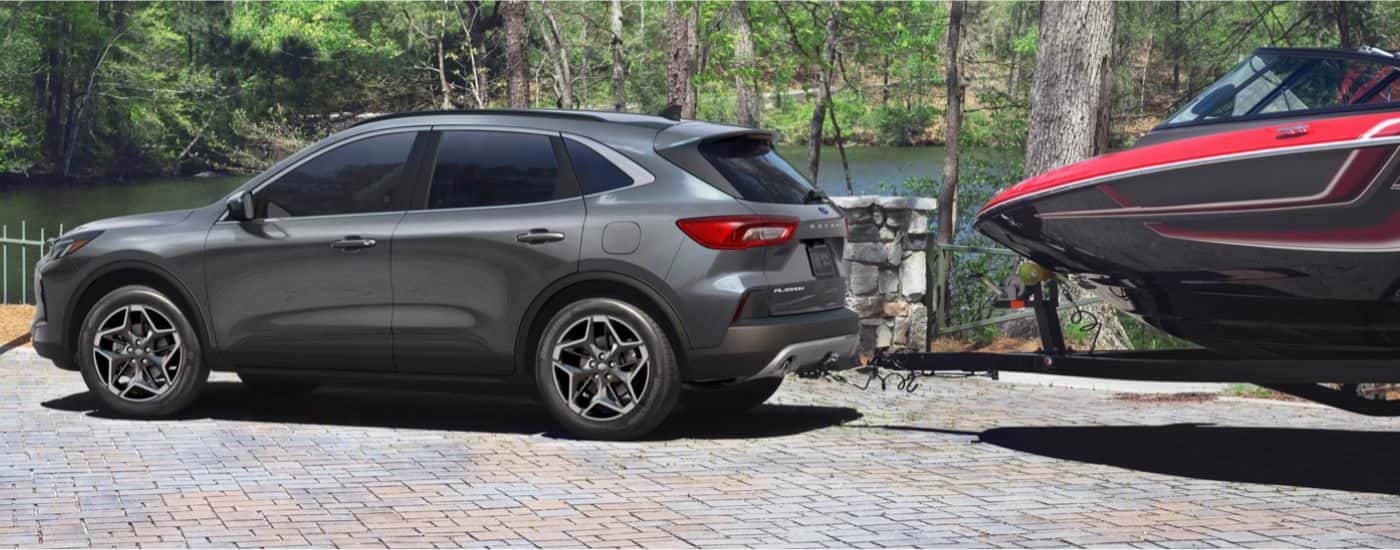 Grey 2026 Ford Escape Platinum towing a boat.