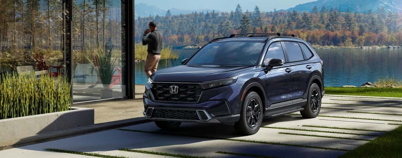Blue 2026 Honda CR-V Hybrid Sport Touring parked near a lake