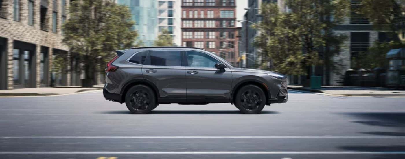 Grey 2024 Honda CR-V driving through an intersection