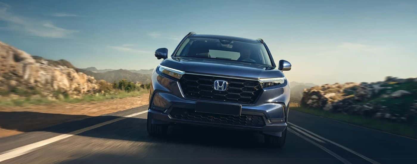 Blue 2025 Honda CR-V Hybrid driving on a highway
