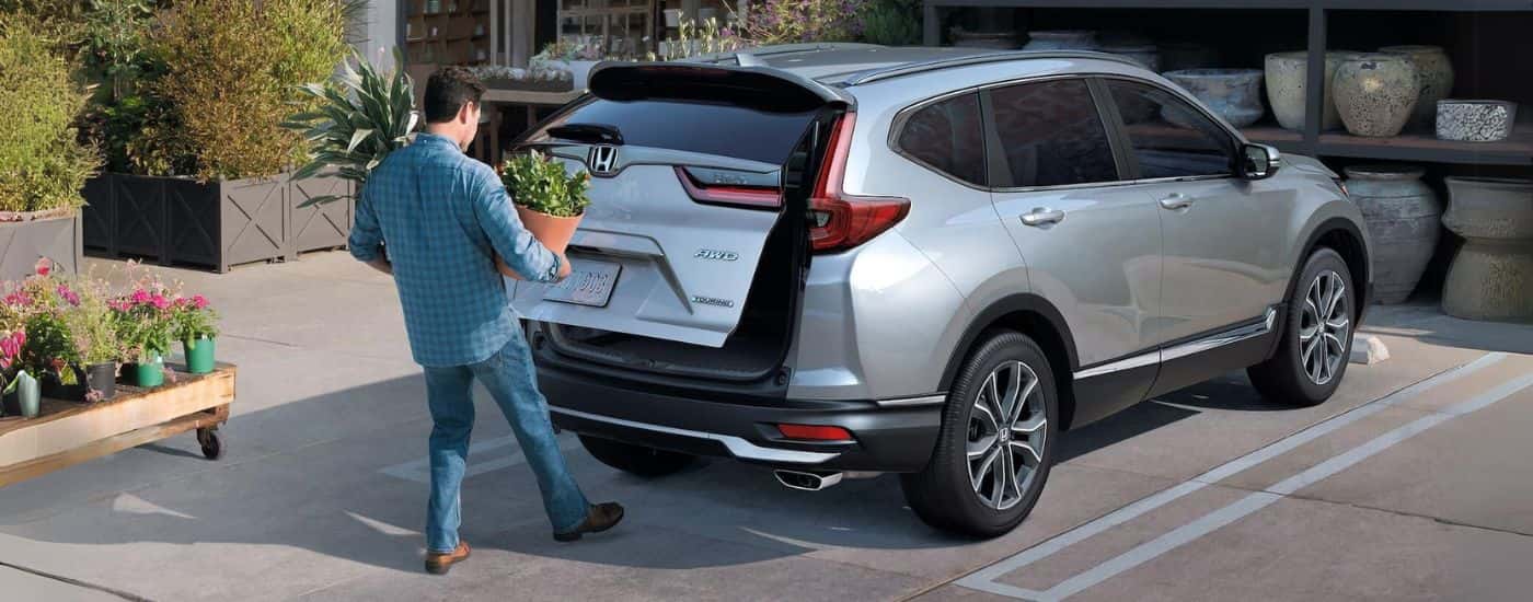 A silver 2021 Honda CR-V Touring with rear gate opening.