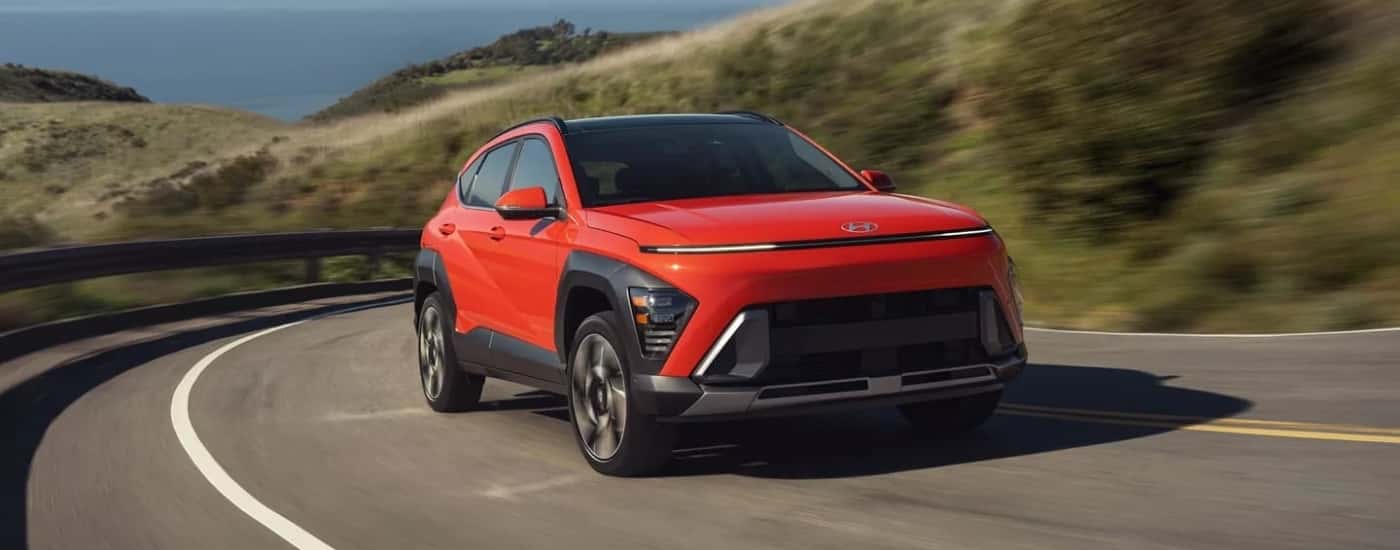 Red 2024 Hyundai Kona Limited rounding a corner