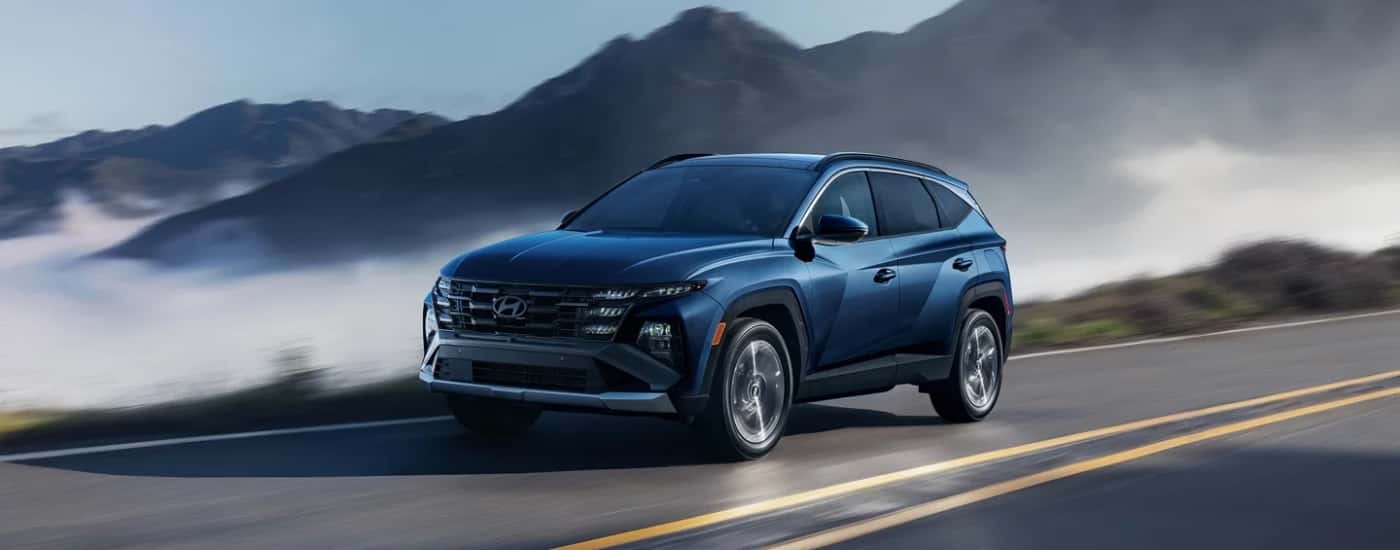 Blue 2026 Hyundai Tucson Limited driving on a mountain pass