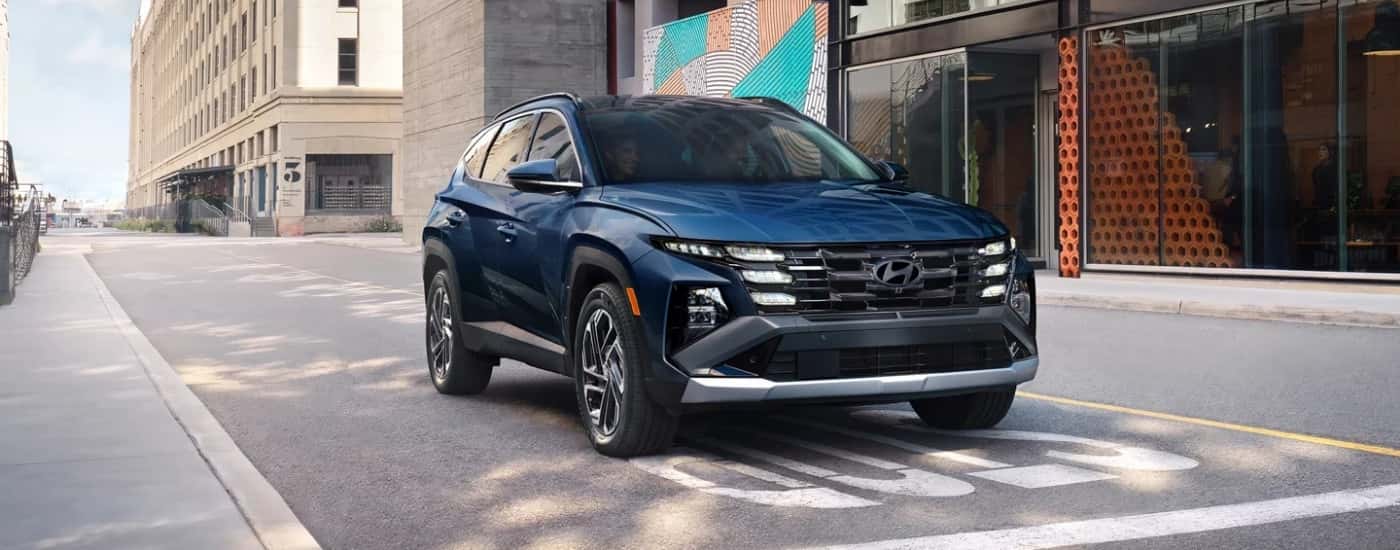 Blue 2026 Hyundai Tucson Hybrid at an intersection
