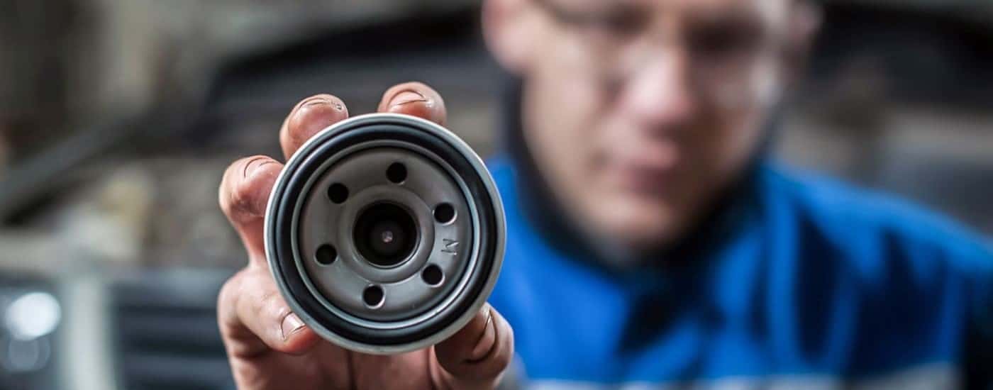 Technician holding and oil filter