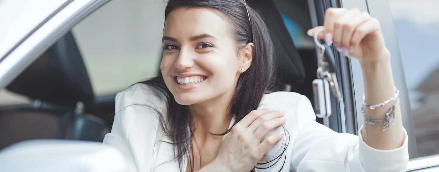 Smiling person holding a car key