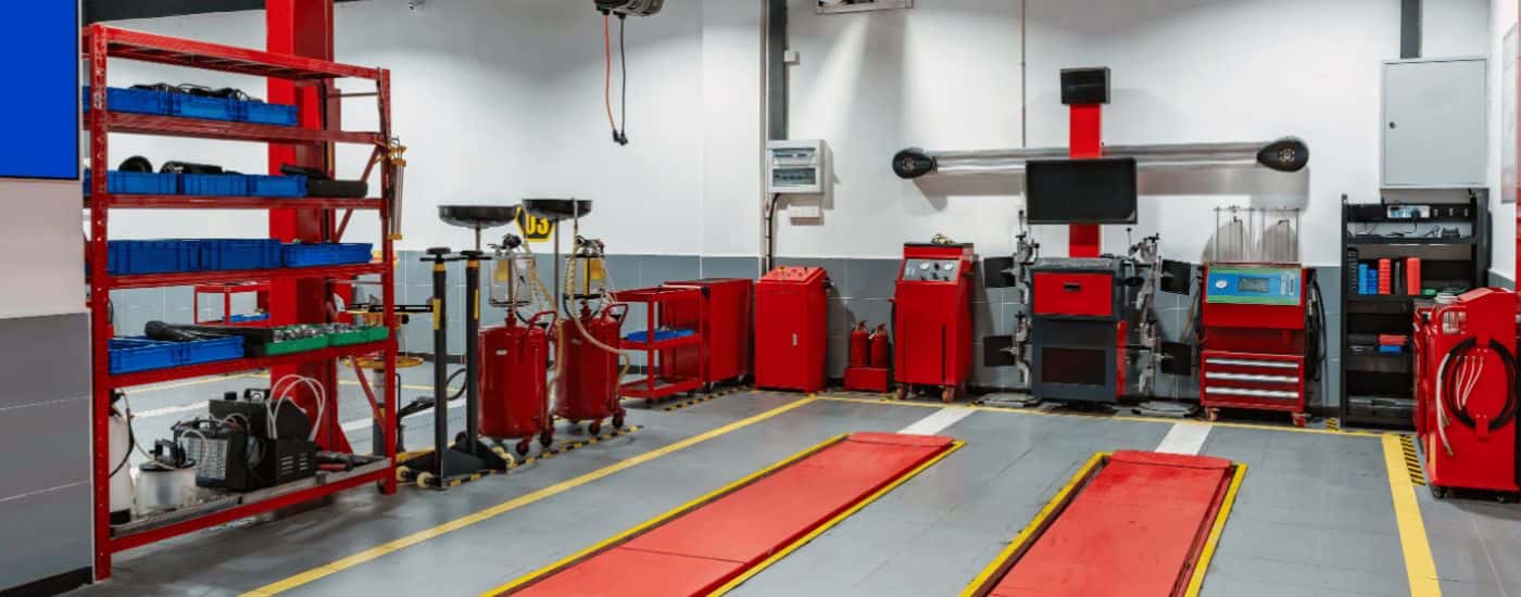 The bay of an auto shop with a red lift.