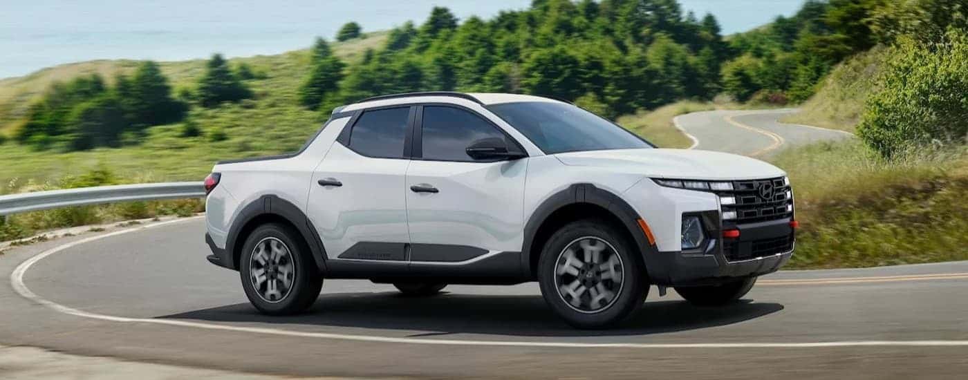 A white 2026 Hyundai Santa Cruz driving on a highway.